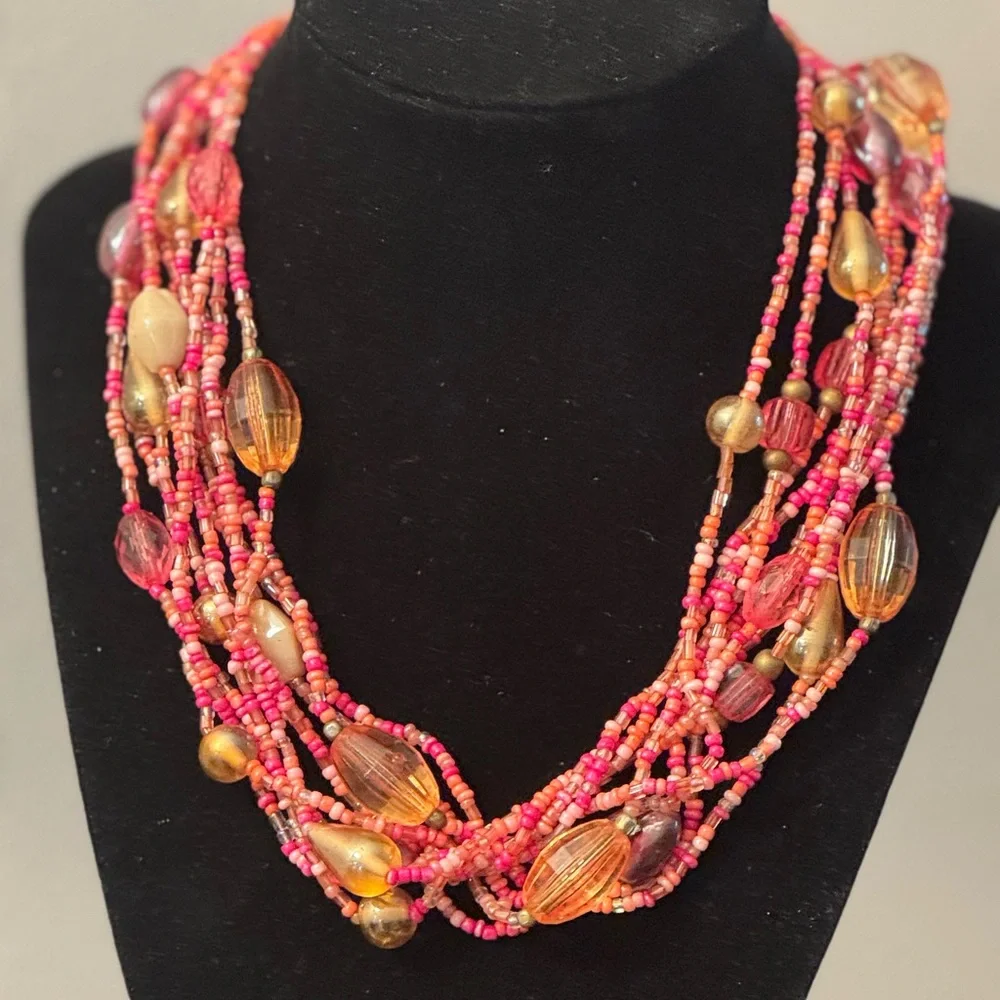 Multi strand torsade style necklace w/coral,pink and salmon colored seed beads